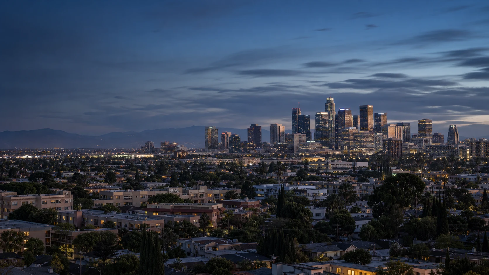 Downtown Los Angeles skyline at blue hour above nearby apartment buildings